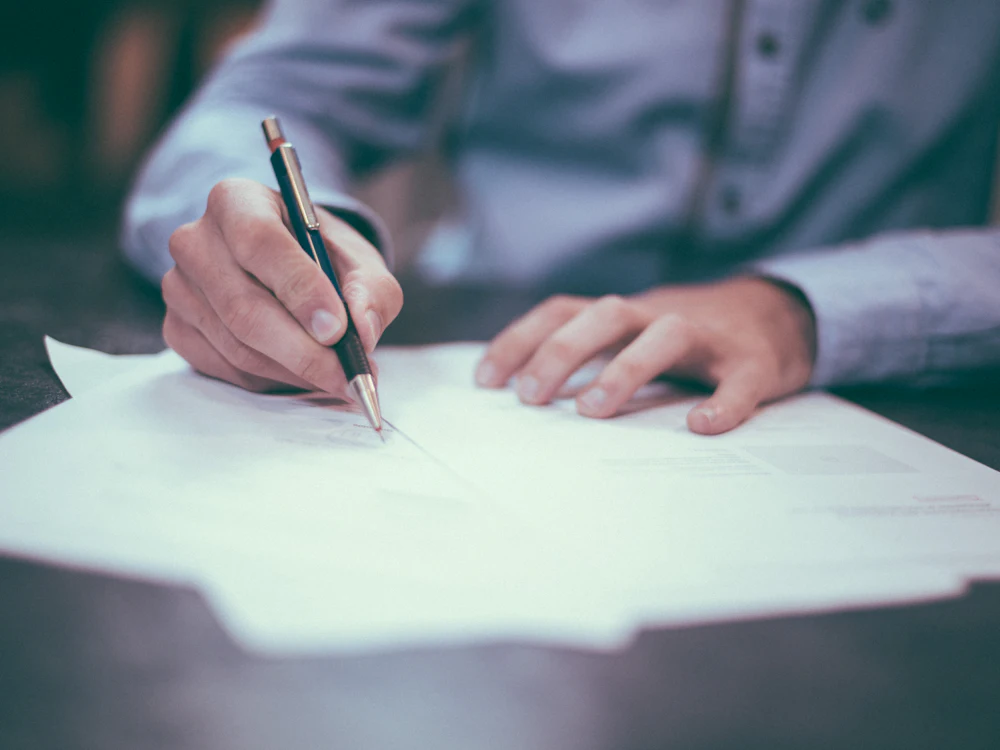 Business owner reviewing and signing a commercial agreement at a desk